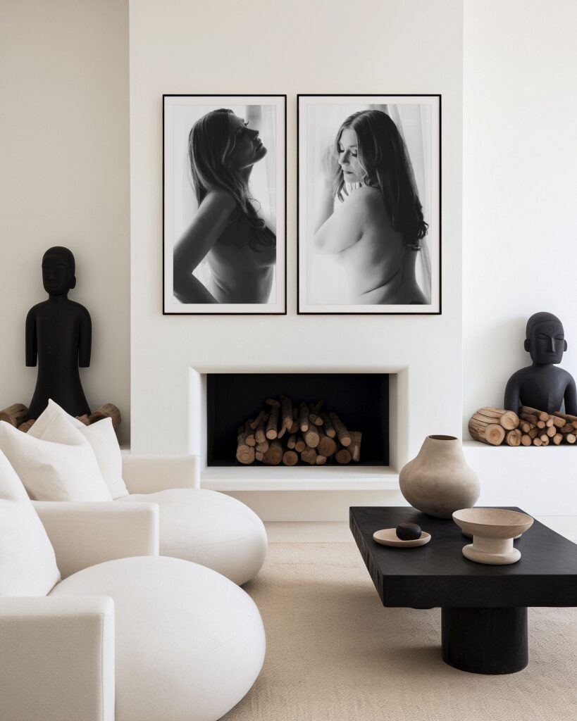 Two framed black-and-white boudoir portraits displayed above a modern fireplace in an elegant neutral living room, showcasing luxury boudoir wall art and fine art portrait photography.